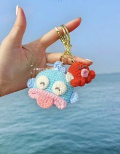 a hand holding two keychains that have been made to look like cartoon characters