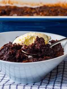 a white bowl filled with cake and ice cream on top of a blue table cloth