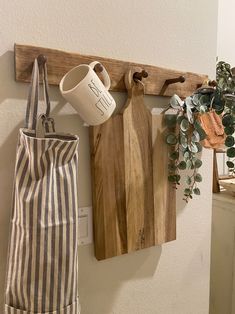 a wooden cutting board sitting on top of a wall next to a potted plant