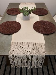 the table is set with place mats and a plant in a vase on top of it