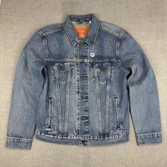 This Classic Levi's Strauss & Co. Denim Jacket, In Size Medium, Is An Embodiment Of Timeless Fashion With A Twist. The Back Features Bold Red And Blue Stripes That Add A Contemporary Flair To The Traditional Denim Look. Constructed From Durable Cotton, It Promises Both Comfort And Longevity. Condition Is New Tag. Button Closures Chest And Side Pockets Red And Blue Stripes On The Back Medium Size 100% Cotton Iconic Levi's Branding Top To Bottom = 25 Inches Pit To Pit = 20 Inches Features: Made In Classic Medium Wash Outerwear For Streetwear, Levi's Casual Denim Jacket In Medium Wash, Levi's Casual Medium Wash Denim Jacket, Levi's Casual Blue Denim Jacket, Classic Denim Blue Outerwear For Streetwear, Classic Blue Levi's Denim Jacket, Levi's Light Wash Outerwear For Streetwear, Levi's Medium Wash Denim Jacket With Pockets, Levi's Blue Casual Denim Jacket