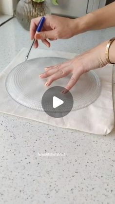 a woman is using a knife to cut up a piece of paper on the counter