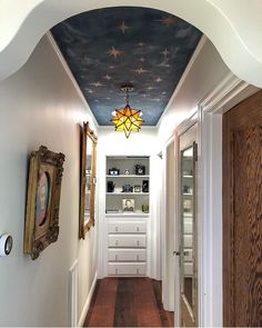 the hallway is decorated in blue and white with stars painted on the ceiling above it