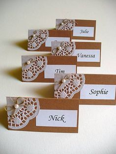 four place cards with lace and pearls on them