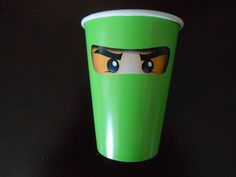 a green cup with eyes painted on it