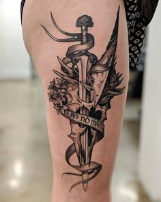 a woman's thigh with a dagger and flowers on it, in black ink