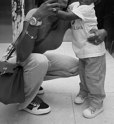 a black and white photo of a woman taking a selfie with her child in front of a mirror