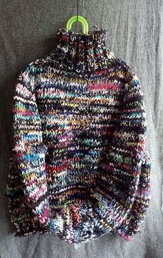 a multicolored sweater hanging on a clothes hanger