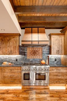 a kitchen with wooden cabinets and stainless steel stove top oven in the center of the room