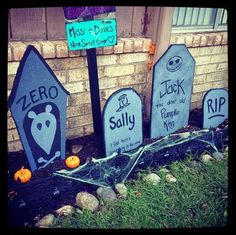 some tombstones are sitting in front of a brick building with halloween decorations on them