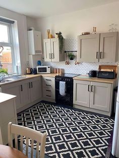 a black and white rug in the middle of a kitchen