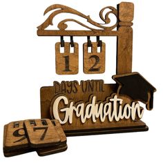 a wooden sign that says graduation and is next to two pieces of wood with numbers on it