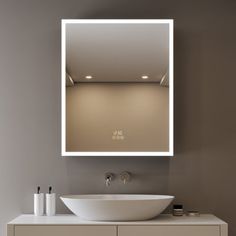 a bathroom with a sink, mirror and lights on the wall above it's counter