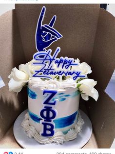 a white and blue cake sitting in a cardboard box