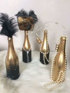 three vases with pearls and black feathers are on a white furnishing area