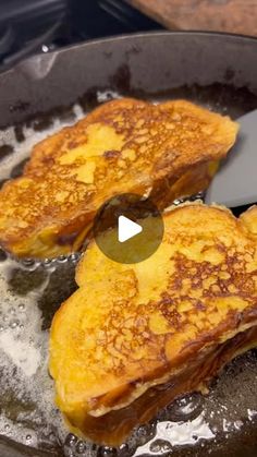 two pieces of french toast frying in a skillet on the stove with oil