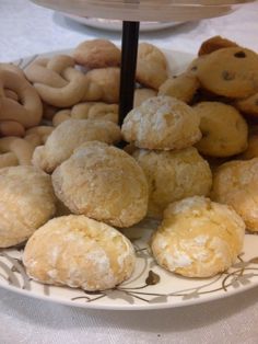 an assortment of pastries are on a plate with a cake stand in the background