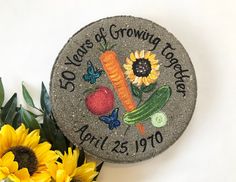 a stone with the words 50 years of growing farmers on it next to sunflowers