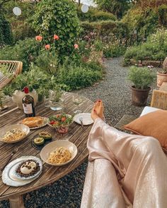 a person sitting at a table with food and wine in front of them on the patio