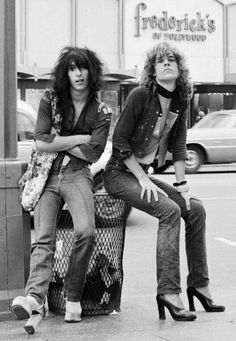 two women sitting on luggage bags in front of a store