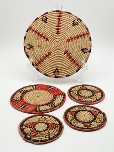 four round woven coasters with designs on the front and back, sitting next to each other