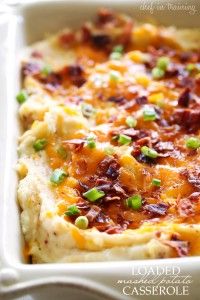 a casserole dish with potatoes, bacon and green onions