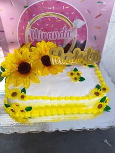 a birthday cake decorated with sunflowers and the word congratulations written on it in gold lettering