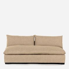 a beige couch with two pillows on it's back and one arm facing the camera