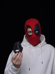 a man in a white hoodie holding a black mask