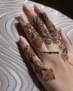 a woman's hand with henna tattoos on it