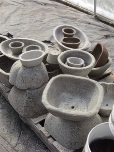 several cement bowls are stacked on top of each other and ready to be used as planters