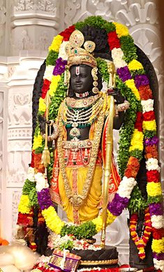 the statue is decorated with flowers and garlands