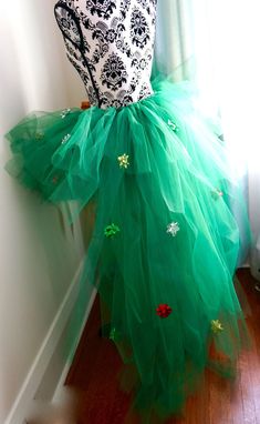 a green tulle skirt with black and white lace on top, sitting against a wall