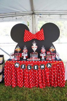 a minnie mouse themed birthday party with red and white polka dot table cloths, mickey mouse