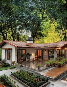 a small white house surrounded by trees and plants