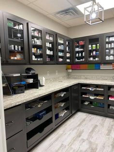 a kitchen with black cabinets and white counter tops is seen in this image, there are many shelves on the wall