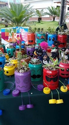 there are many different colored pots with plants in them on the table next to each other