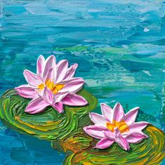 two pink water lilies floating on top of green lily pads in the blue water