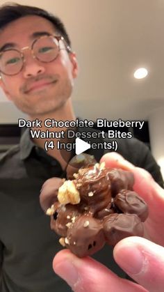 a man holding up a chocolate blueberry walnut desert in front of his face with the caption dark chocolate blueberry walnut dessert bites 4 ingredients