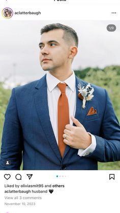 a man in a blue suit and orange tie is looking at the camera while wearing an orange flower boutonniere