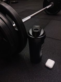 a close up of a barbell and a cup on the ground