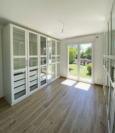 an empty room with glass doors and wood flooring