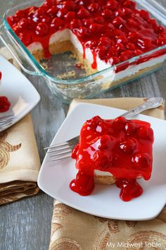 a piece of cheesecake covered in cherries on a plate