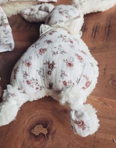 a stuffed animal laying on top of a wooden table