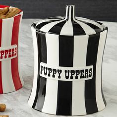 two black and white striped canisters with words puppy uppers written on them