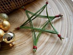 a star ornament sitting on top of a wooden table next to christmas ornaments