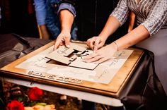 two people are cutting up a piece of paper