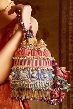 Multi-color potli bag with bead tassels, meenakari worked beads, pearl embellishments and lace trims. 
Embroidered
Composition: Brocade
Color: Multi Color
Tassel pull out drawchord
Chain tassels
Size (cm): Dia x H: 15 x 26
Note: Wristlet shown in the image is not for sale - Aza Fashions Potli Bags, Tarun Tahiliani, Beaded Bags, Beaded Tassels, Diy Arts And Crafts, Printed Bags, Heart Print, Online Accessories, Aza Fashion