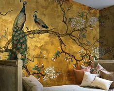 peacocks are sitting on the branches of a tree in front of a gold wall