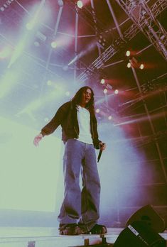 a man standing on top of a stage holding a skateboard